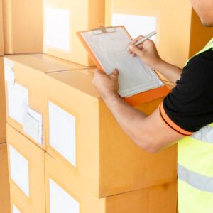 person taking notes by a pile of boxes