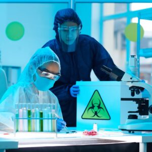 two scientists taking notes near a box with a biohazard symbol