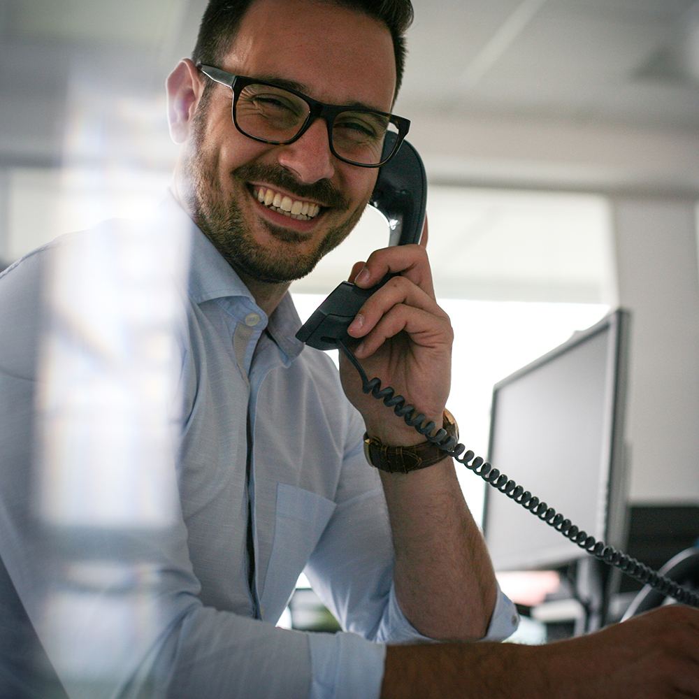 man smiling while on the phone